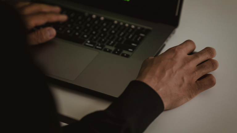 Ciemna scena z laptopem ilustrująca temat dark patterns i prywatności użytkowników