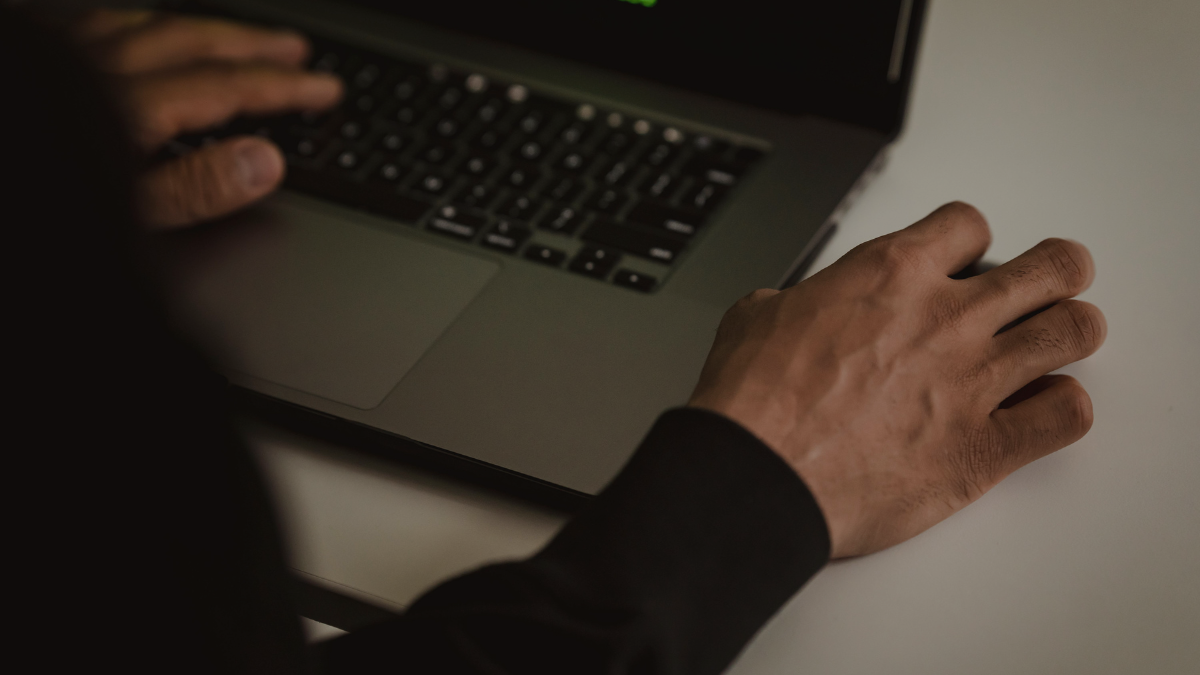 Ciemna scena z laptopem ilustrująca temat dark patterns i prywatności użytkowników